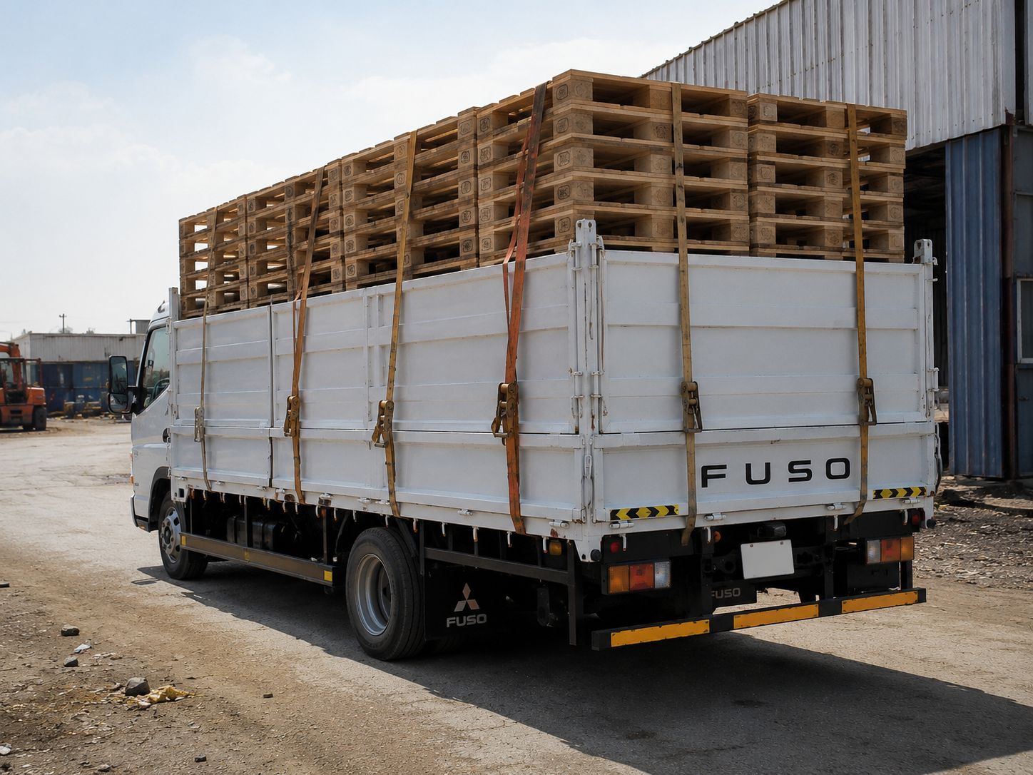 A truck loaded with finished pallets leaving the yard